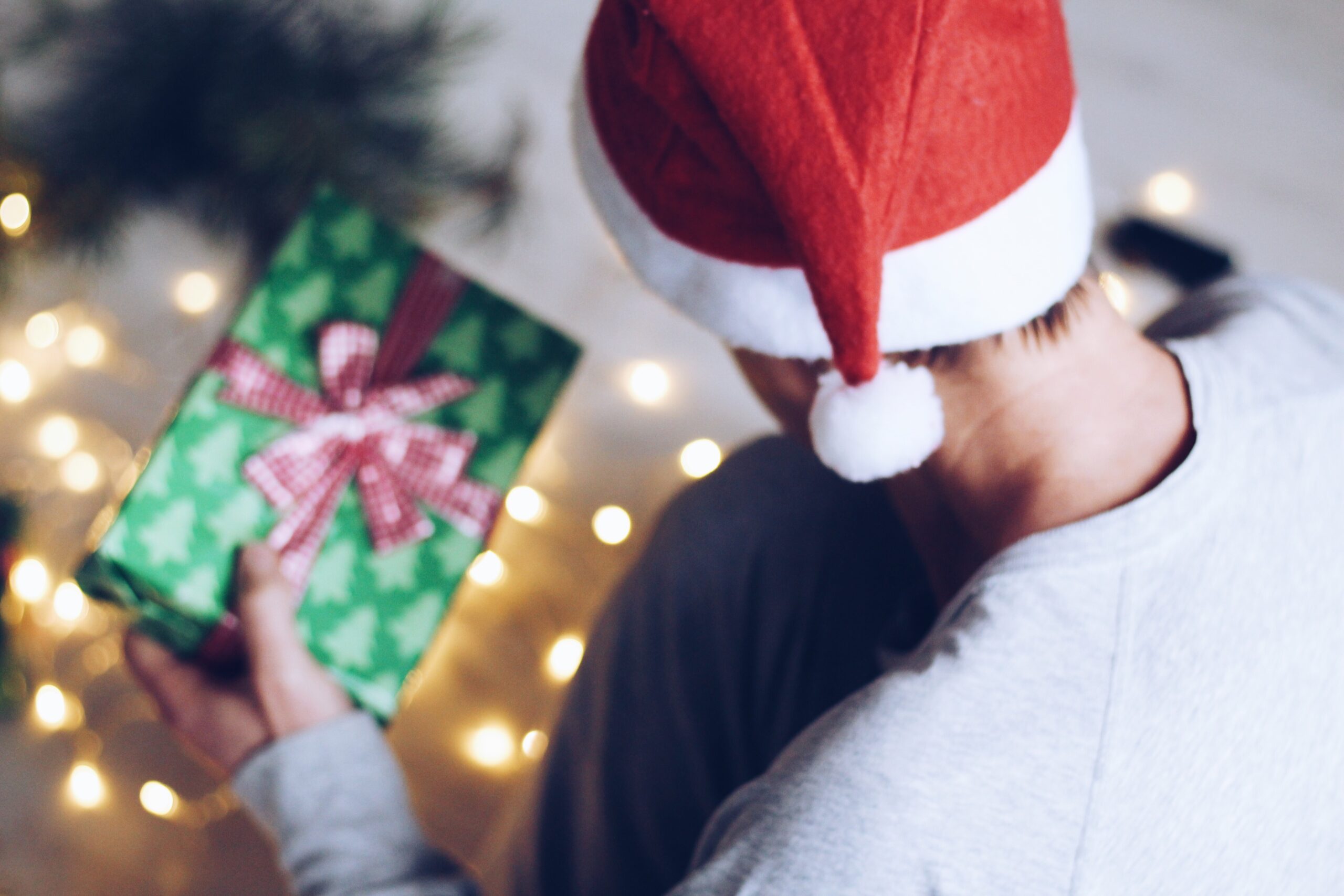 Mann hält Weihnachtsgeschenk in der Hand.