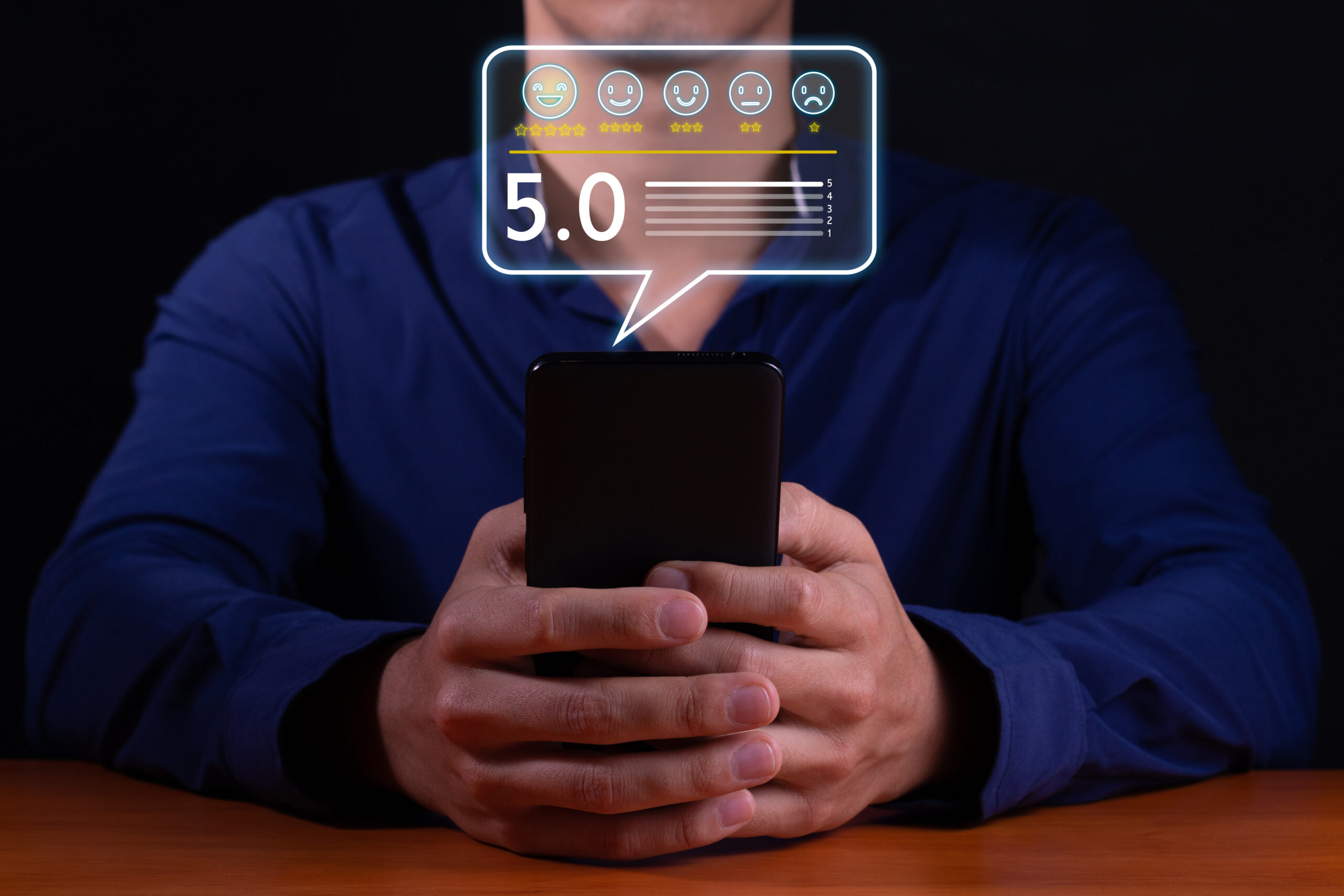 Mann bewertet etwas auf seinem Smartphone. Er kann maximal 5 Sterne vertgeben.