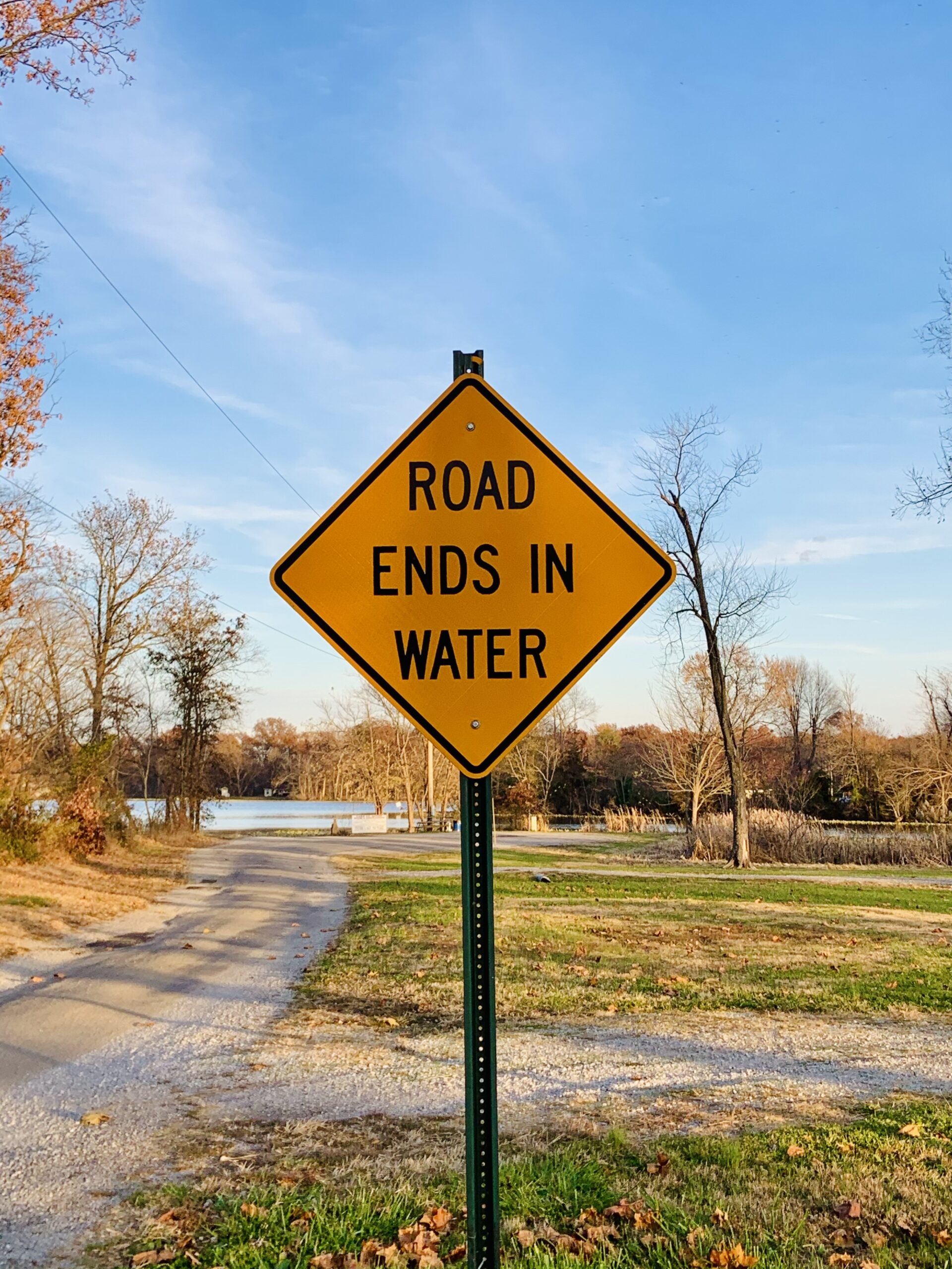 Eine schmale Straße, die ins Wasser führt mit entsprechendem Warnhinweis.